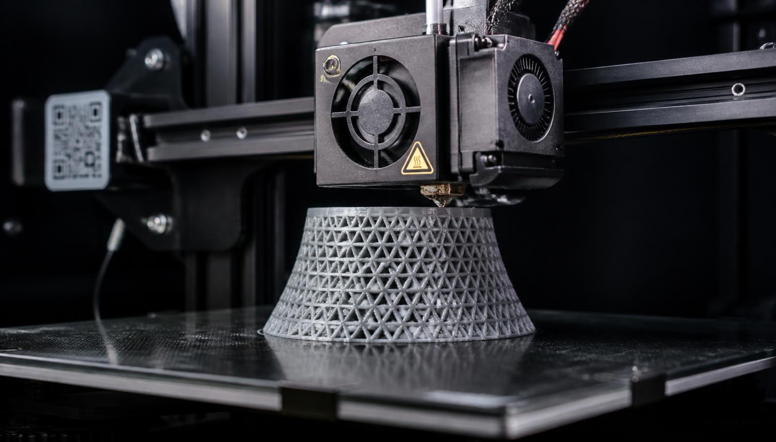 FDM 3D printer building a lattice-structured part layer by layer