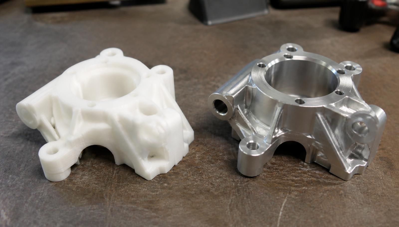 3D printed prototype part beside the equivalent machined aluminium component