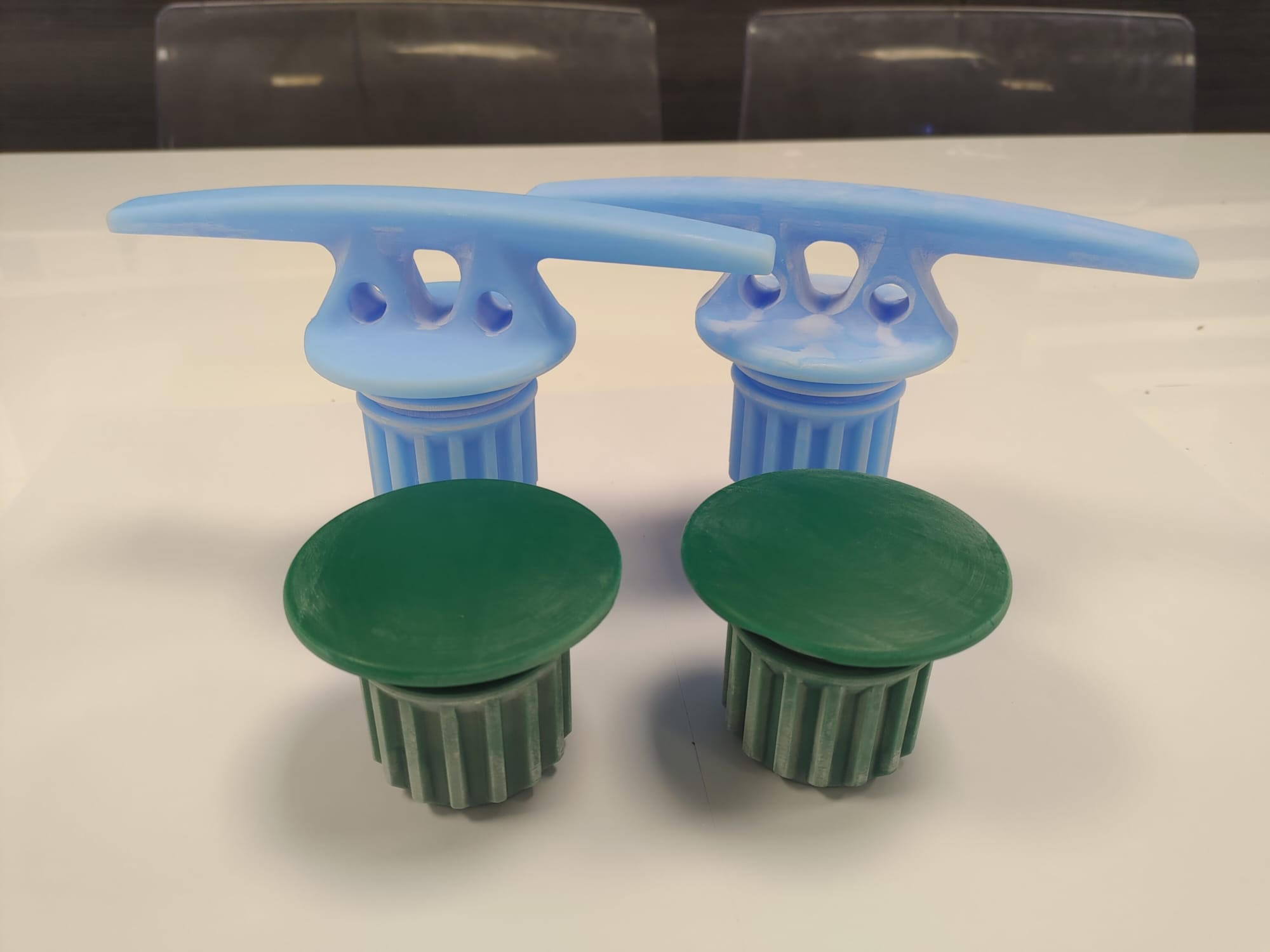 Cleat and stopper cap wax patterns side by side, cleaned and ready for gating